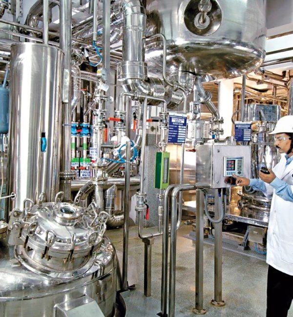 Photograph of a technician working at a pharmaceutical chemical plant in India.