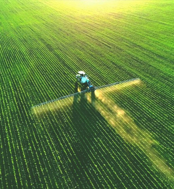 Tractor spray fertilizer on green field drone high angle view, agriculture background concept.